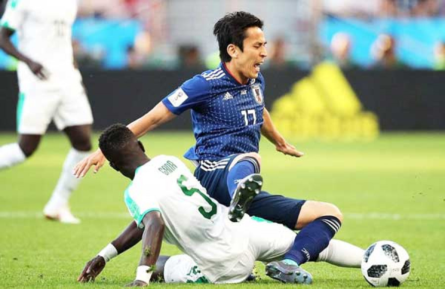 Pemain Jepang Makoto Hasebe dijegal gelandang Senegal Idrissa Gana Gueye pada pertandingan Grup H