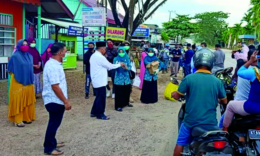 Bupati Berau H Muharram bersama istri membagi-bagikan takjil dan masker terhadap warga pengguna jalan. ( Foto: istimewa )