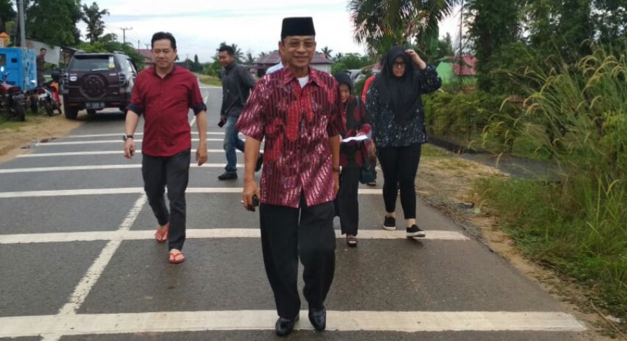 Mustaqim MZ bersama keluarganya menuju TPS 1 Desa Girimukti (erwin/korankaltim.com)