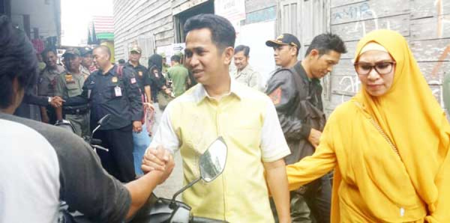 WAKIL Wali Kota Rahmad Mas’ud bersama istrinya, menyalami warga di sela masa pencoblosan Pilgub Kaltim, Rabu (27/6) kemarin.