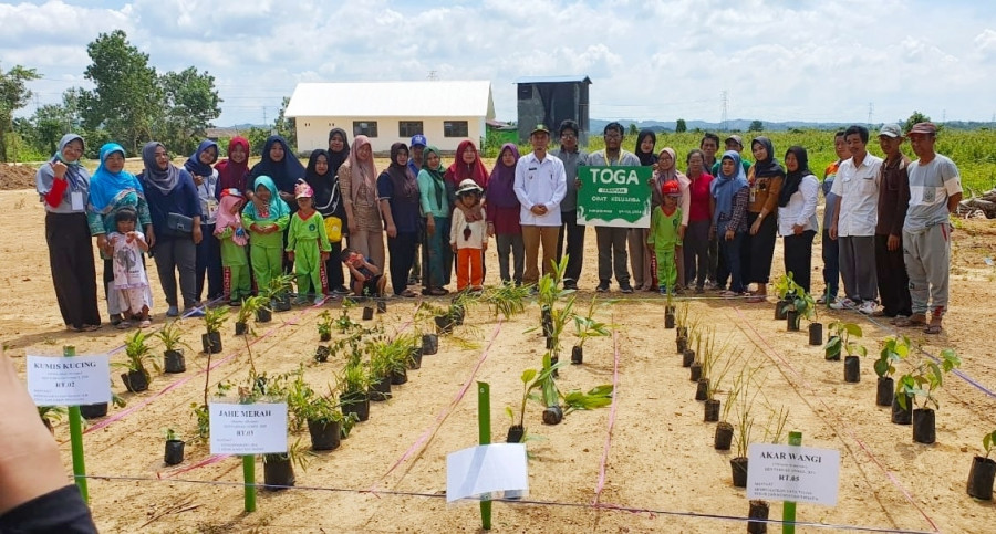 Kepala Desa Tanjung Batu, Husniyansyah dan Ketua TP PKK Desa Tanjung Batu, Nurul Huda berfoto bersama warga dan mahasiswa Unmul yang sedang melaksanakan KKN, di sela pembagian bibit tanaman herbal. Foto: Istimewa