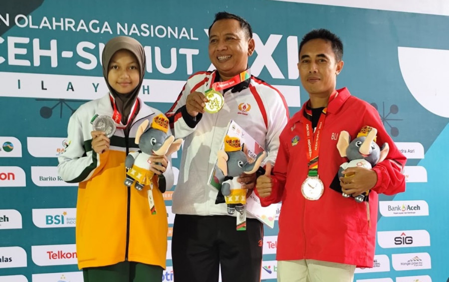 Aretha (kiri) pegang medali perak di nomor 25 meter cabor menembak. (Foto: Ainur/Korankaltim.com)