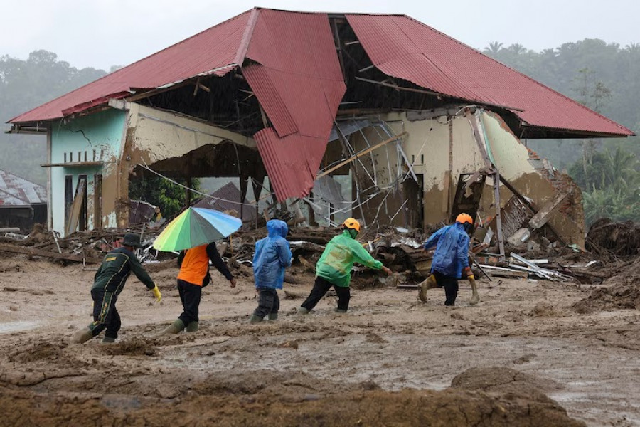 Tim penyelamat melewati lumpur sementara operasi pencarian dan penyelamatan terus berlanjut di wilayah yang dilanda banjir bandang mematikan menyusul hujan deras di Palembayan, Kabupaten Agam, Provinsi Sumatra Barat (reuters)