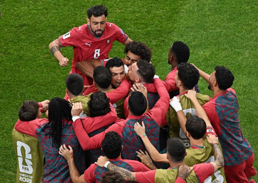 Cristiano Ronaldo disambut pemain-pemain Portugal setelah mencetak gol ke gawang Uzbekistan pada pertandingan dini hari tadi. (Foto: Reuters)