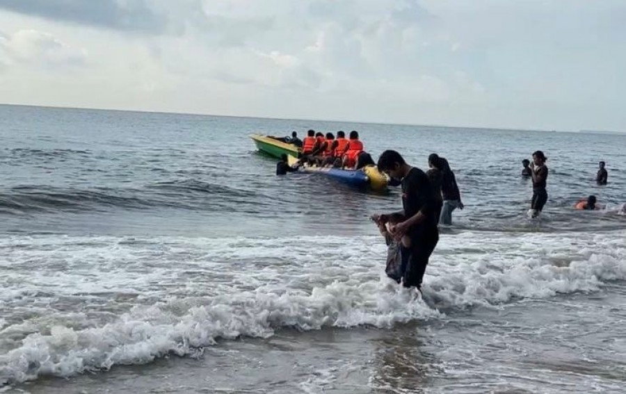 Pengunjung saat mandi dan mencoba wahana Banana Boat di Pantai Pantita Lopi, Kecamatan Muara Badak. (Foto: Muhammad Anshori/Korankaltim.com)