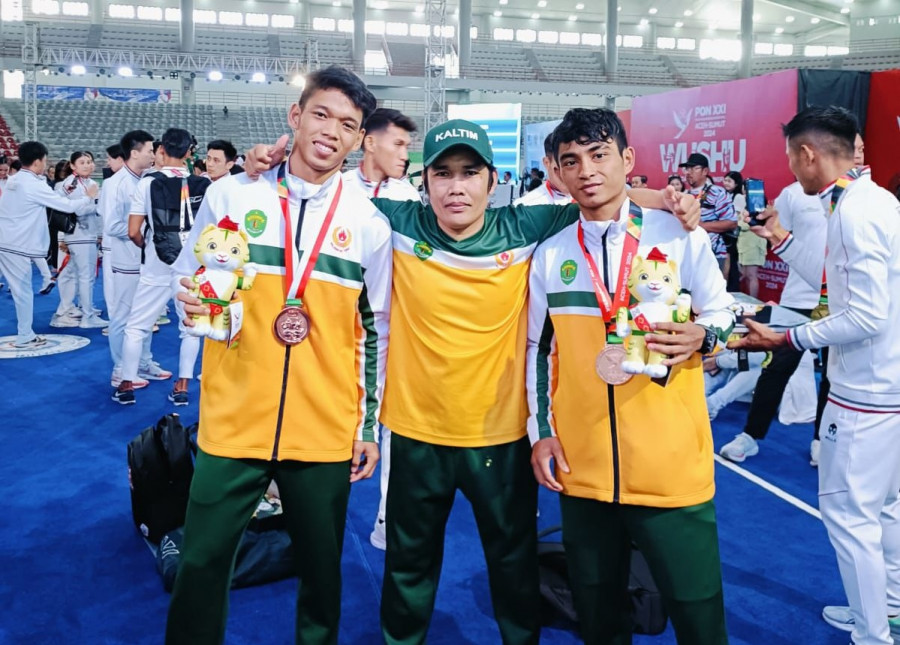 Dua atlet wushu Kaltim bersama pelatih di venue tanding. (Foto: Istimewa)