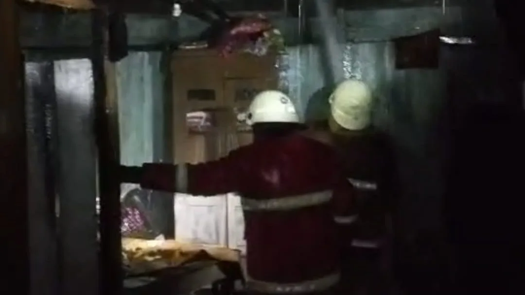 Proses pendinginan bagian belakang bangunan rumah warga di Kecamatan Tenggarong Seberang yang terbakar. (Dok. Damkar Matan Kukar)