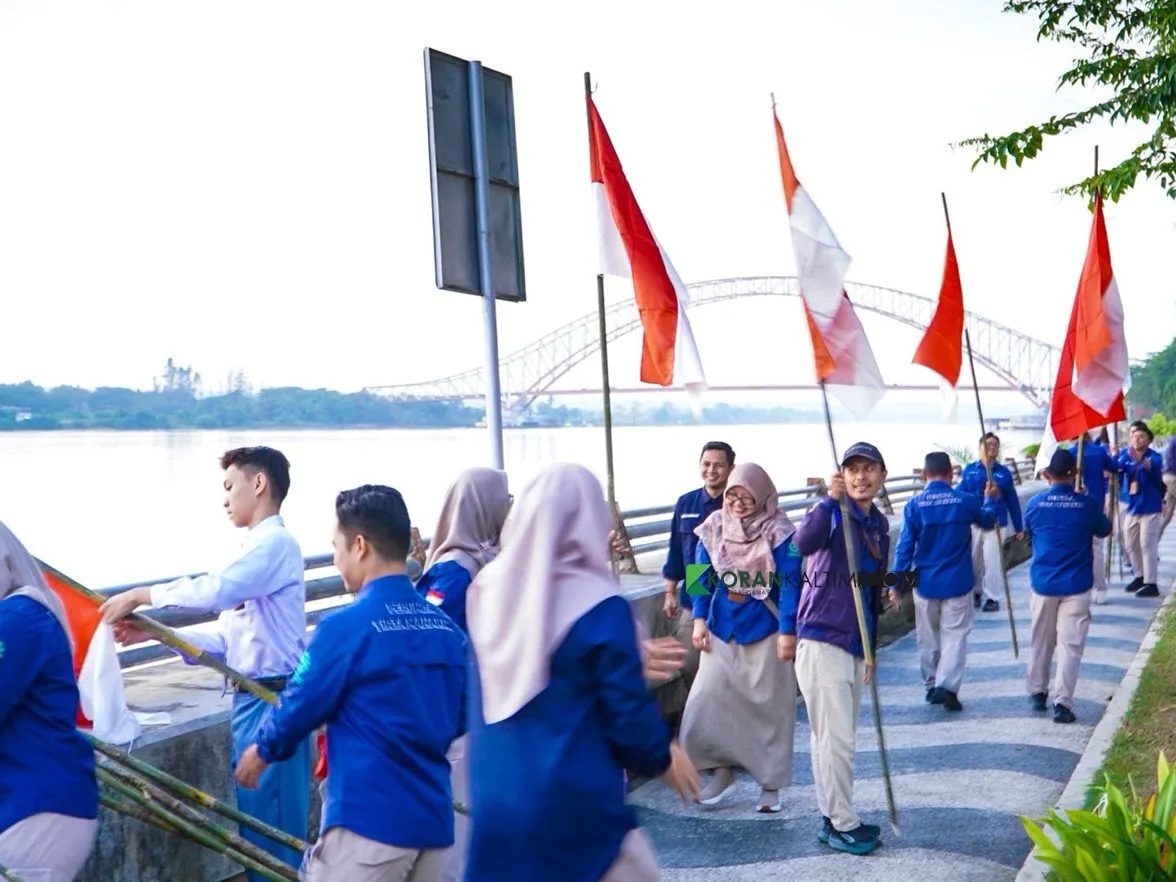 Kebersamaan tukang ledeng Perumda Tirta Mahakam dalam membagikan dan memasang bendera Merah Putih. (Foto: Heri/Korankaltim.com)